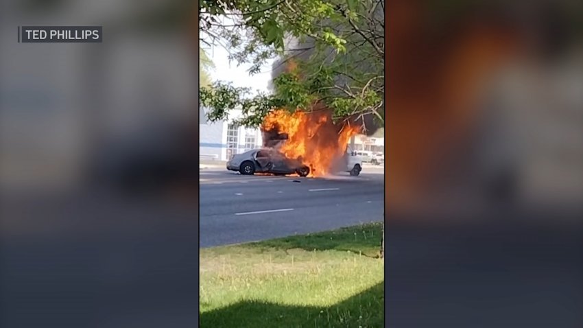 A white Chrysler sedan bursts into flames after a crash following a police pursuit.