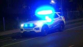 A white and blue Chicago police car is pictured at night, with its blue lights illuminated.