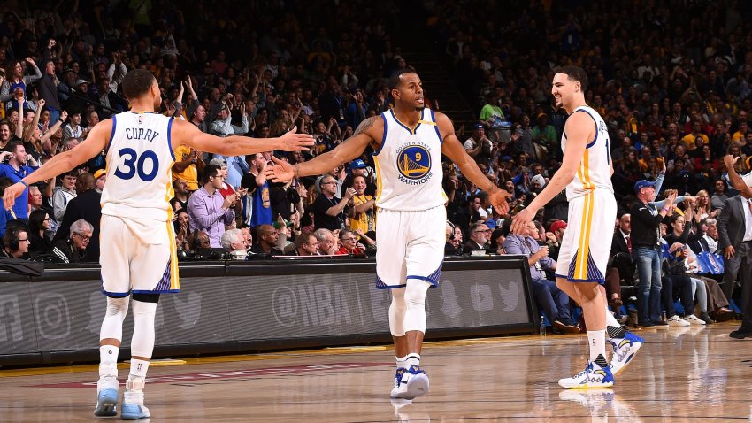 Andre Iguodala, #9; Stephen Curry, #30; and Klay Thompson, #11, of the Golden State Warriors high-five one another during the game against the Boston Celtics at the Oakland Arena in Oakland, California, on March 8, 2017.