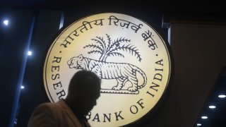 People walk past Reserve Bank of India signage in front of an installation stall at Global Fintech Fest in Mumbai, India, on Aug. 28, 2024.
