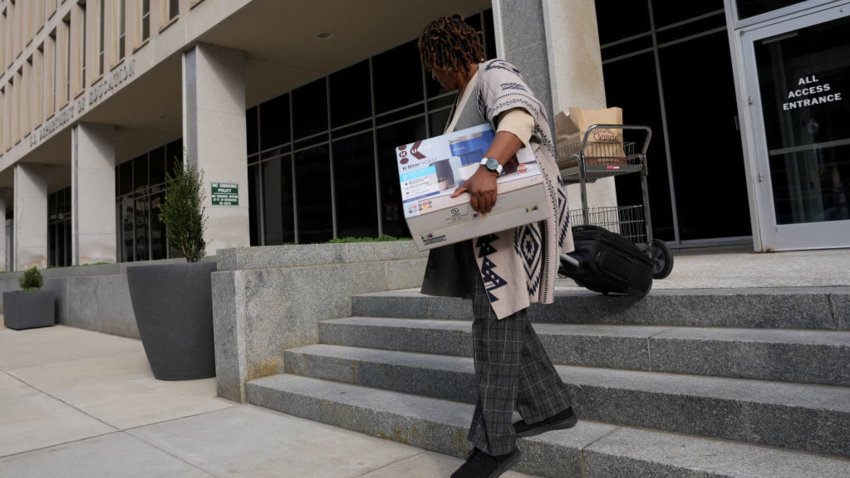 A U.S. Department of Education employee leaves the building with their belonging on March 20, 2025 in Washington, DC.