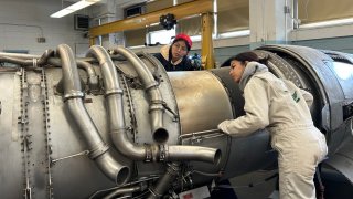 Students work on an airplane engine at Aviation High School in Queens.