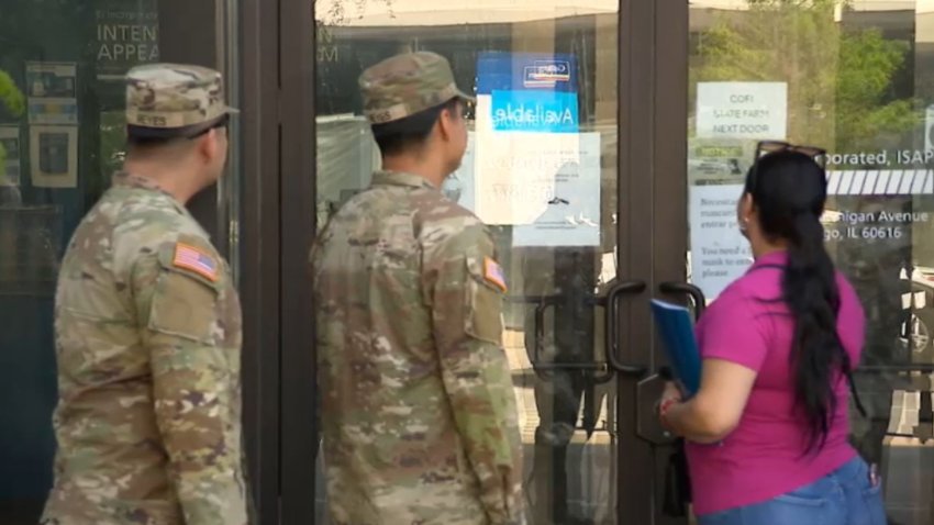 Mujer acompañada de sus dos hijos en uniforme de la Guardia Nacional.