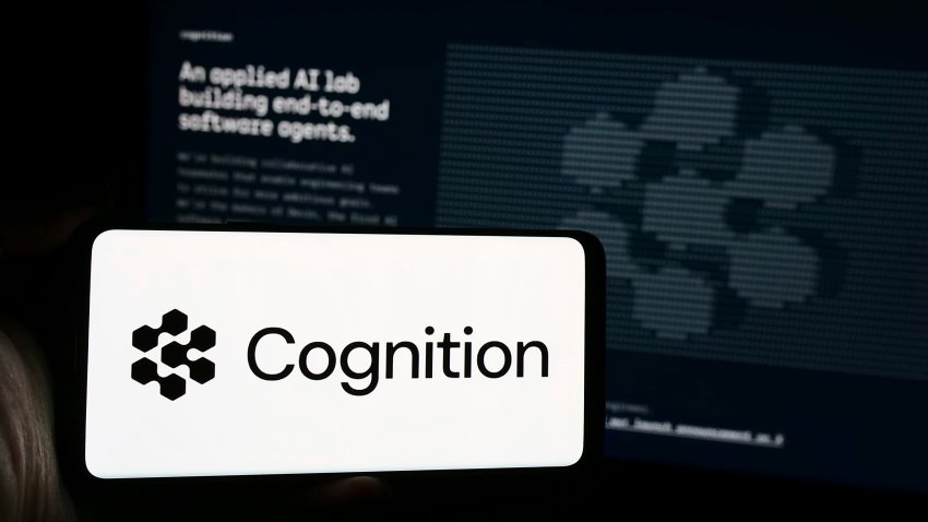 In this photo illustration, a man seen holding a smartphone with the logo of US artificial intelligence company Cognition AI Inc. in front of website.