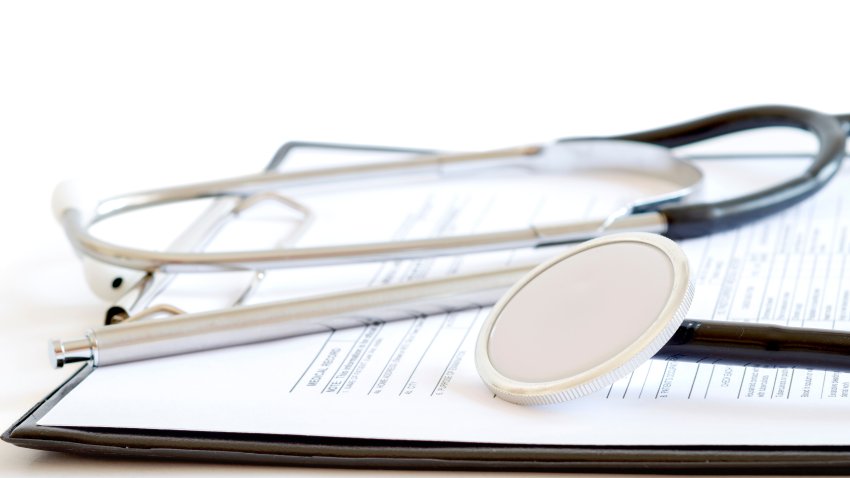 Medical forms below a stethoscope.