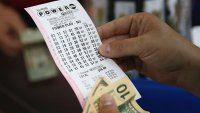 CHICAGO, IL – AUGUST 07:  A customer at a 7-Eleven store checks the numbers on his Powerball lottery ticket on August 7, 2013 in Chicago, Illinois. The Powerball jackpot for tonight’s drawing is $425 million, the third-highest total ever.  (Photo by Scott Olson/Getty Images)