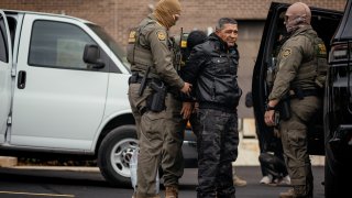 Immigration and Customs Enforcement agents take people they detained earlier to a parking lot before transferring them to an ICE facility in Chicago on Oct. 31.