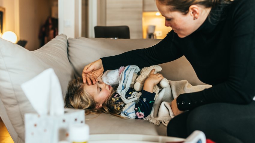 Woman using her hand to check temperature of her child..The girl has a flue and feeling sick.