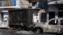A man walks past burned vehicles in Puerto Vallarta, Jalisco State, Mexico, on February 24, 2026. Known as a sunny tourist paradise, parts of the coastal city of Puerto Vallarta seem more like the set of a war film in the aftermath of violent chaos spurred by the capture and death of Mexico's most-wanted drug lord. (Photo by Alfredo ESTRELLA / AFP via Getty Images)