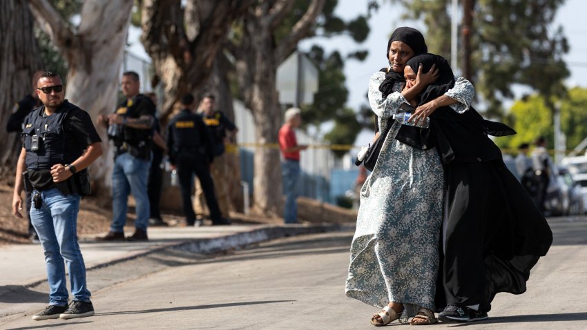 TOPSHOT - Two women react as they leave a reunification center following the shooting at the Islamic Center of San Diego in southern California, on May 18, 2026. A shooting at the largest mosque complex in San Diego killed three people, with two suspected teenage gunmen later found dead in a car from self-inflicted gunshot wounds, police said.
