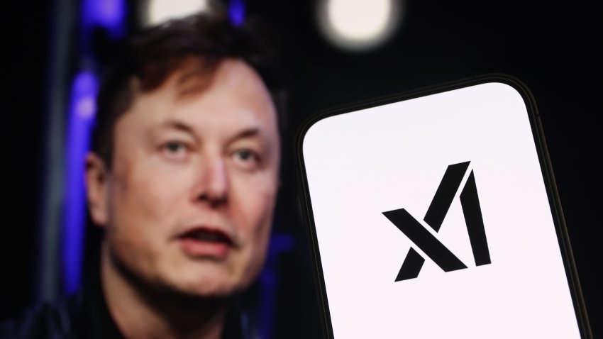 In this photo illustration, logo of 'xAI' is displayed on a mobile phone screen in front of Elon Musk's photo in Anka...