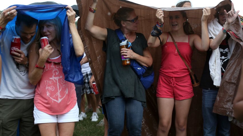 From left, Steve Geick, Audrae Stephen, Kirsten Brown, Hadley Brown, and Austin Brown take shelter from the rain Friday, August 1, 2014, at Lollapalooza in Chicago’s Grant Park. (Jessica Tezak/Chicago Tribune/Tribune News Service via Getty Images)